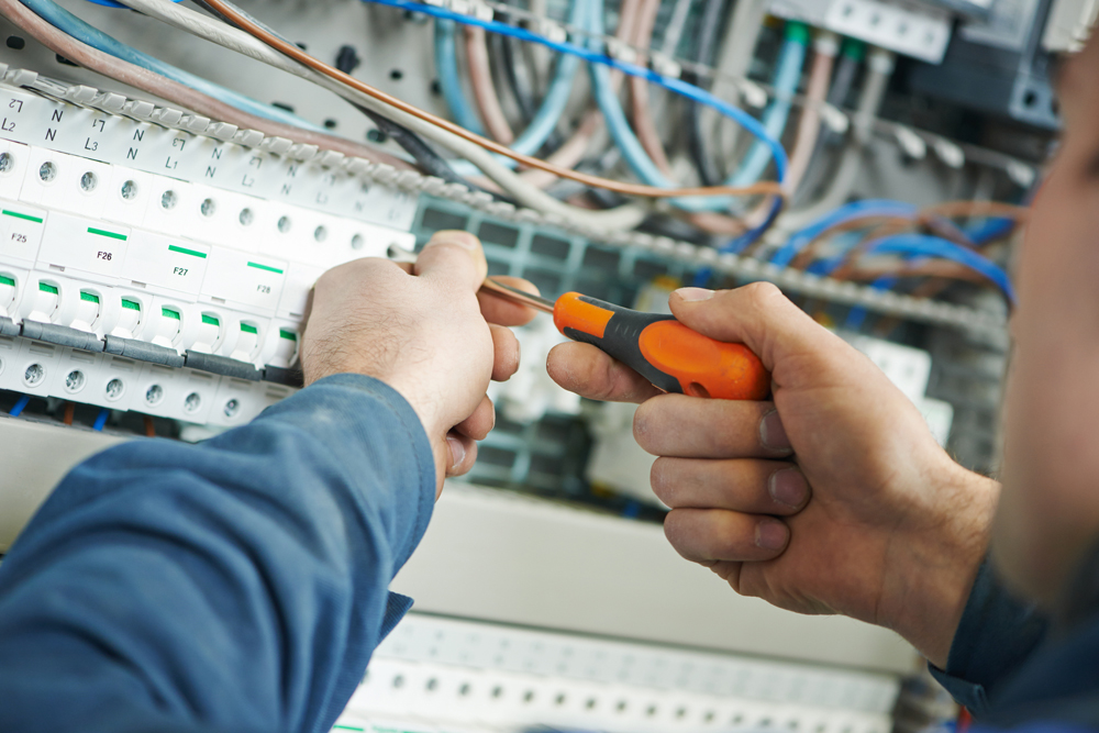 Vakman werkt aan automatische zekeringen in een zekeringkast